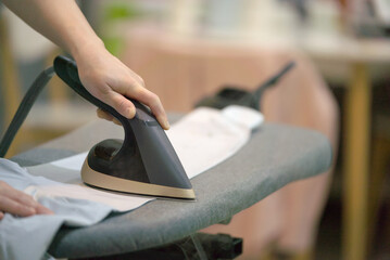 Person Ironing Clothes on an Ironing Board