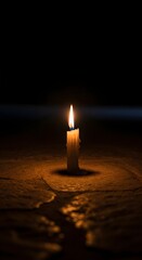 A single lit candle casting a warm glow on a dark surface, creating a peaceful and contemplative atmosphere in a dimly lit environment