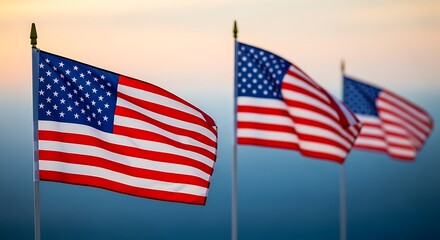 Fototapeta premium American flags waving in the wind against a clear sky at sunset