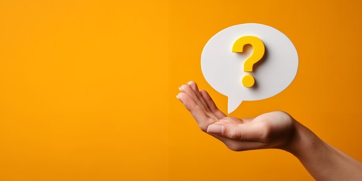 Hand holding speech bubble with yellow question mark on vivid orange backdrop. Concept for problem solving, information request and decision making