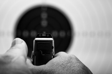 Close up at rear gun sight aiming to Bull eye target  , Black and white background