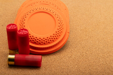 Clay disc flying targets and shotgun bullets on cork background ,Clay Pigeon target