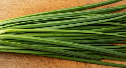 Fresh green chives on a wooden cutting board, culinary herb.