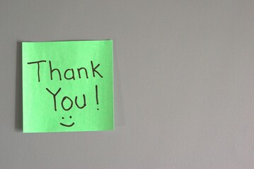 green sticky note with "Thank You!" handwritten in black marker and a small smiley face
