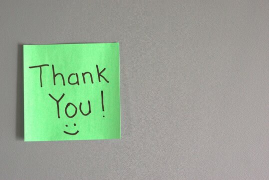 green sticky note with "Thank You!" handwritten in black marker and a small smiley face