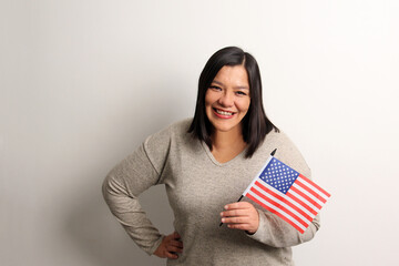 40-year-old Latina woman proudly displays the United States flag as a symbol of migration and freedom