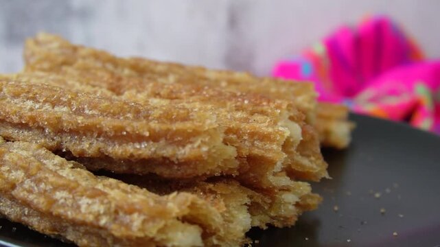 Rotating plate with churros with cinnamon and sugar, Mexican food