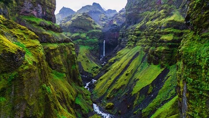 Explore the natural beauty of Mulagljufur Canyon in Iceland with lush greenery and waterfalls
