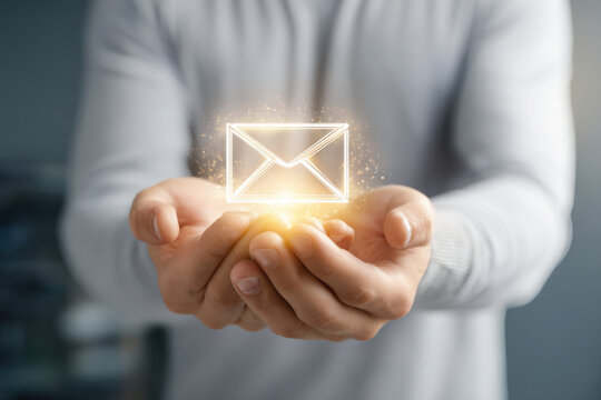Man presenting a glowing email icon in his hands for digital communication