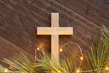 Close up cross with evergreen and mini lights