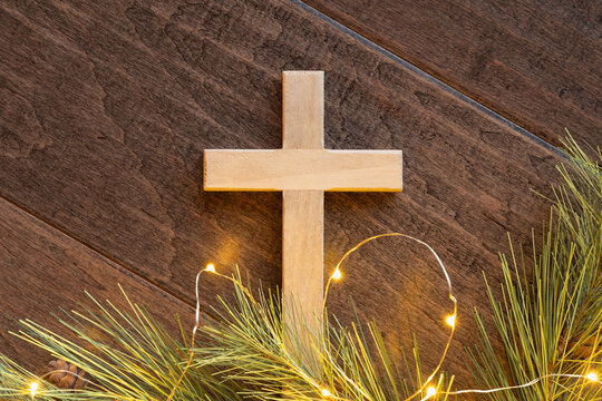 Close up cross with evergreen and mini lights