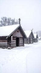 Several quaint, snow-covered wooden structures line a path, amidst a foggy, wintery scene, evoking a historical setting