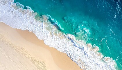 Aerial view of a sandy beach, pristine waves, turquoise ocean, and a white foamy shore. Warm sand meets ocean