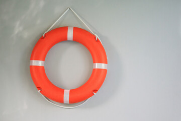 Bright orange lifebuoy hanging on the wall