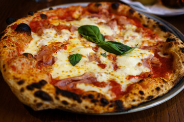 Freshly Baked Traditional Prosciutto Pizza with Mozzarella and Basil