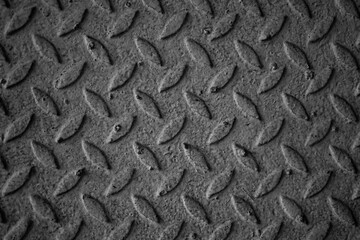 Fototapeta premium A black and white photo of a metal surface with a pattern of diamond shapes