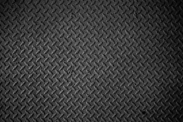 A black and white photo of a metal surface with a pattern of squares
