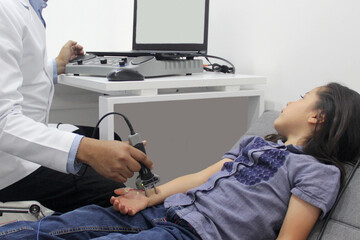 Electromyography EMG and Nerve Conduction Velocity NCV of the hand and arm in a 6-year-old Latina girl with a doctor