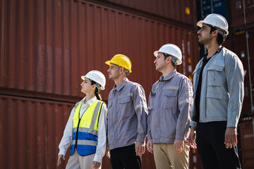 Engineer and worker team working in logistic terminal of container cargo, Diverse construction team in safety gear outdoors