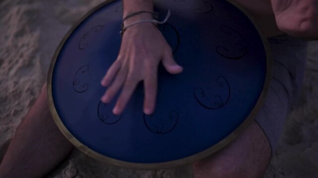 man playing blue rav vast on the beach in the late afternoon.