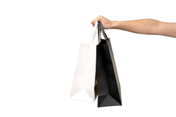 A person's hand holding a paper shopping bag with handles on a clean white background. Studio shot with ample copy space for text, logos, or branding. Isolated on white, cut out.