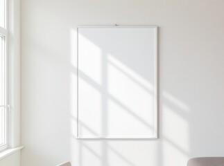 Blank white poster frame on wall with soft window light