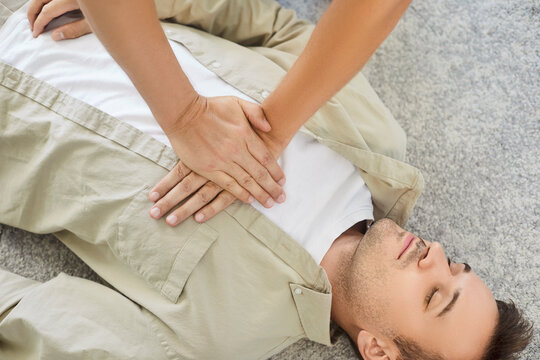 CPR chest compressions assist patient in emergency resuscitation. Hands press the chest of an unresponsive unconscious man. A rescuer gives first aid to patient. Lifesaving skills concept. 