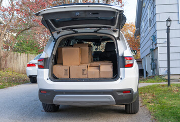 SUV with paper cardboard boxes in SUV trunk