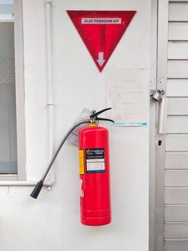 Light fire extinguisher "Alat Pemadam Api" (APAR) on white wall on August 27, 2024 in Bandung, Indonesia