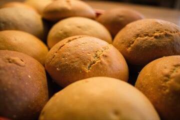 A variety of freshly baked breads, from soft rolls to dense loaves, piled high, representing abundant deliciousness. A visually abundant, overhead shot of a diverse selection of freshly baked breads,