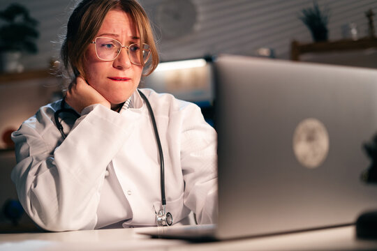 Doctor in Hospital Office with laptop analyzing documents and medical data working during night shift. - Powered by Adobe