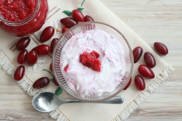 Dessert from cottage cheese and homemade preserved  jam from Cornelian cherry dogwood, lat. Cornus mas macrocarpa. Fresh berries on embroidered napkin, flat lay.