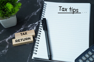 Tax tips and financial planning concept with calculator and tax return blocks