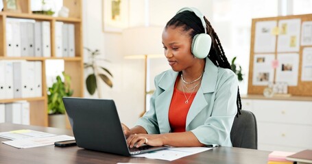 Headphones, laptop and typing with business black woman in office to review sales report statistics. Computer, data and music with African employee at desk in workplace for accounting or management