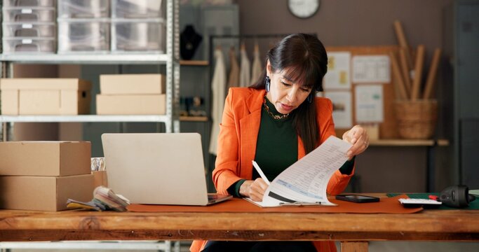 Logistics, woman and writing on checklist for small business, inventory or fashion supply chain. Ecommerce, clipboard and mature entrepreneur with delivery document, stock and shipping in office - Powered by Adobe