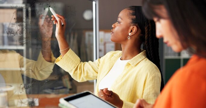 Small business, fashion and women writing with teamwork for strategy, clothing design ideas and planning. Startup, meeting and people with glass wall, tablet and ecommerce for supplier or logistics - Powered by Adobe