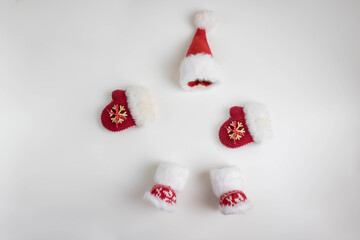 Santa's mittens, a red cap, and knitted red boots. A New Year's concept