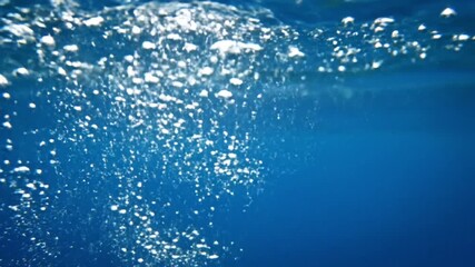 Underwater view of rising bubbles in clear blue water creating a mesmerizing aquatic atmosphere scene - Powered by Adobe