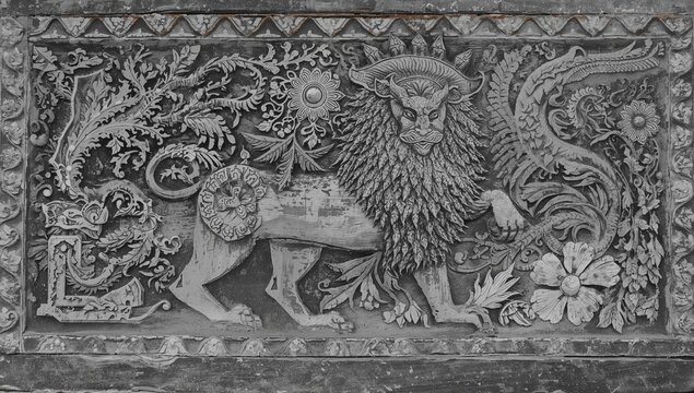 A traditional Batak Toba wood carving, Gorga singa singa, showcasing intricate designs and worn textures, rich in cultural history.