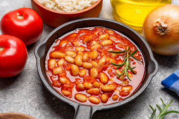 Baked bean dish in cast iron pan on vintage background