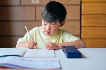 家で漢字の練習をする小学生の男の子