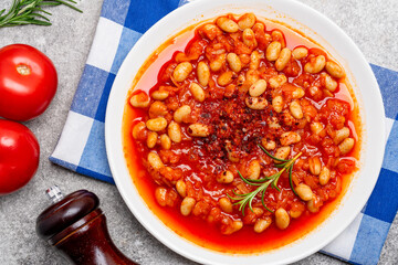 Baked bean dish in cast iron pan on vintage background.