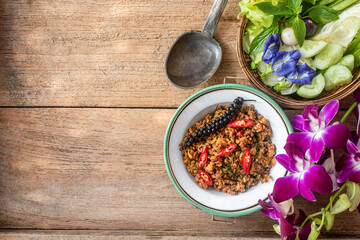 A plate of traditional Southern Thai Khua Kling stir-fried minced pork served in a rustic bowl, topped with red chili and sliced kaffir lime leaves. 