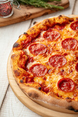 Hot pepperoni pizza with tomato sauce and melted cheese served on a wooden board