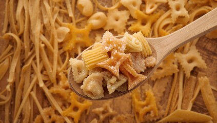 Selection of raw pasta on a wooden spoon, suitable for culinary presentations