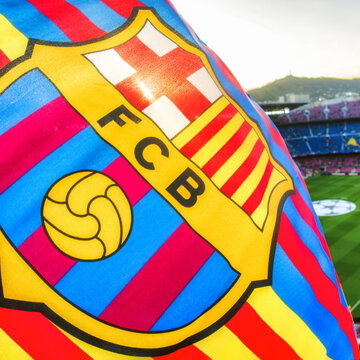 FC Barcelona flag waving inside football stadium with vibrant team colors during match atmosphere and supporter excitement