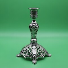 An ornate silver candlestick holder with intricate detailing and a decorative base set against a vibrant green background