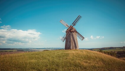 Old windmill on a hillside farm, vintage technology amidst summer landscape, preservation