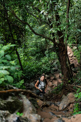 Woman hiking lush green tropical forest trail