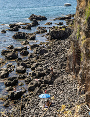 Looking down onto the volcanic beach of Aci Castello, just north of Catania, Sicily, known for its stunning coastal views, rocky shores, and historical landmarks